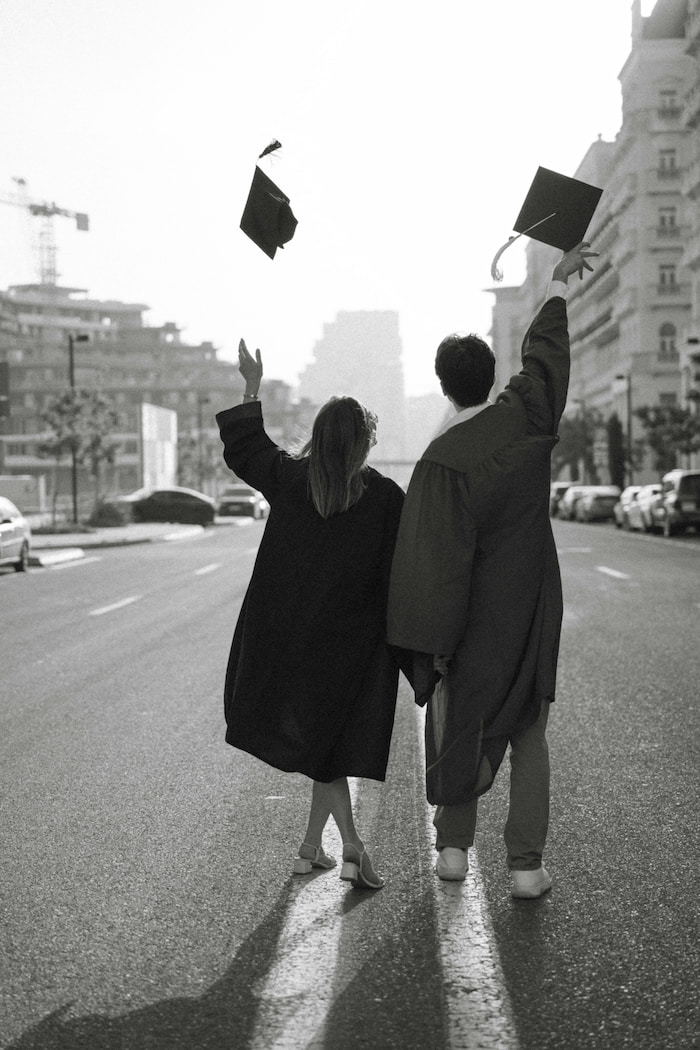 Graduation photography Houston TX - young couple celebrating graduation throwing caps